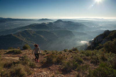 Woman runs through the mountains of montserrat in catalonia, spain.