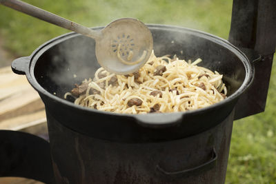 Cooking pilaf. the food is fried in a frying pan. lunch in nature. national uzbek dish pilaf.