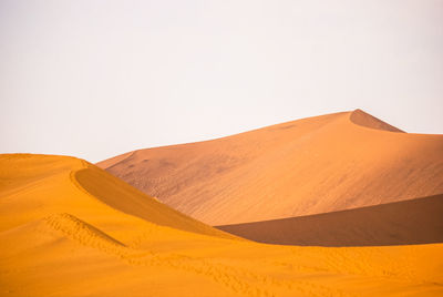 View of sand dunes in desert against clear sky