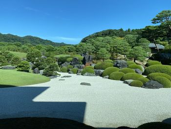 Scenic view of formal garden against clear blue sky