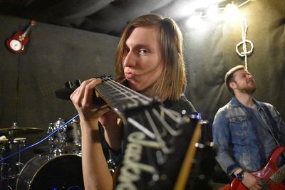 Portrait of man playing guitar at music concert