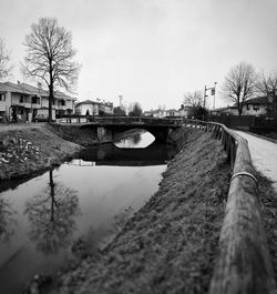 Bridge over canal in city against sky