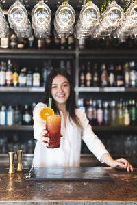 Portrait of a woman holding drink in restaurant