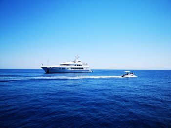 Sailboat sailing on sea against clear sky