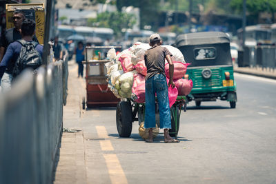 Rear view of people walking on street in city