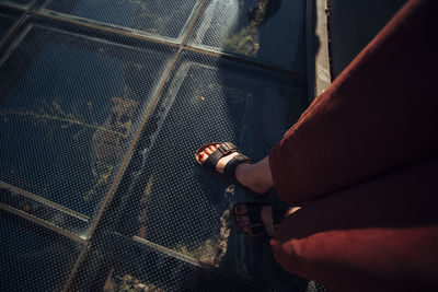 Low section of man sitting on escalator