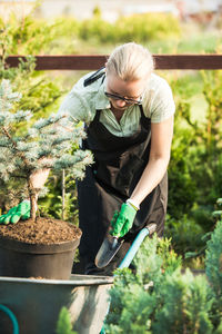 Full length of woman standing in flower pot