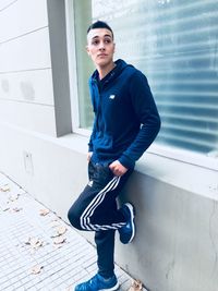 Portrait of young man looking away against wall