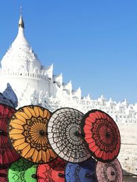 Low angle view of clock on white temple against sky