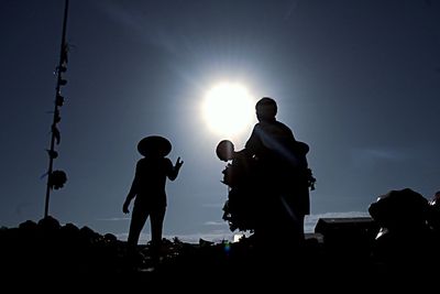 Low angle view of silhouette people against sky