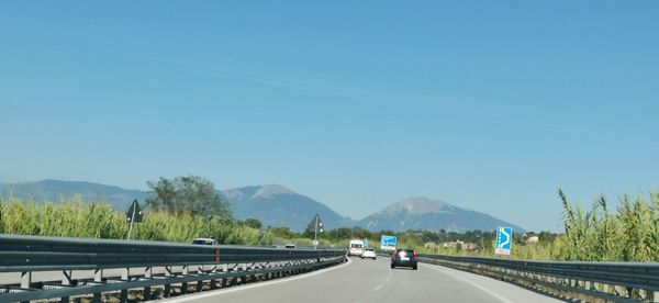 Cars on highway against clear sky