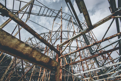 Low angle view of rusty metallic structure against sky