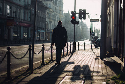 Rear view of people walking on street in city