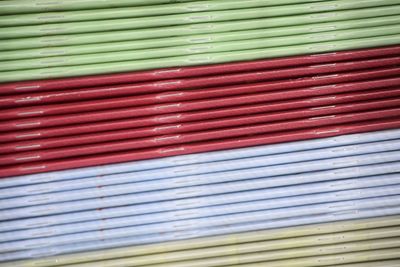 Books with different colours lying together with patterns, red, green and white stripers