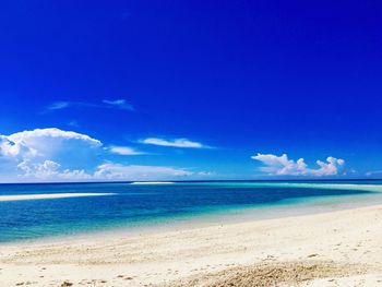 Scenic view of beach against blue sky