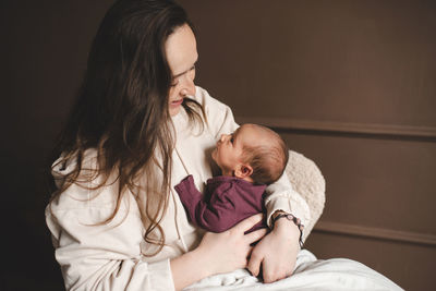 Smiling mother embracing baby