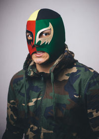 Close-up of man wearing mask against gray background