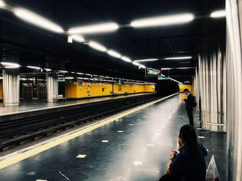 Man standing at railroad station platform