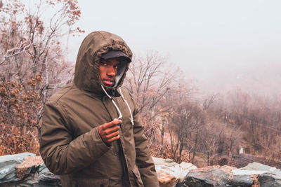 Portrait of young man standing in snow