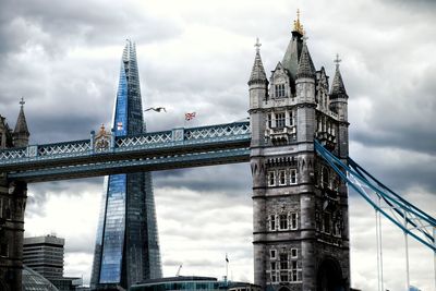 Low angle view of bridge against cloudy sky