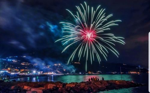 Firework display over sea at night