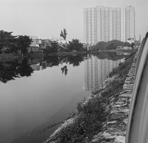 Scenic view of lake by buildings against sky