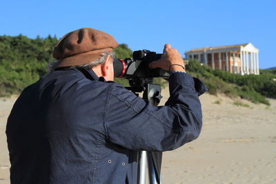 Movie set, cameraman at work, background of neoclassical building and beach