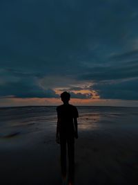 Rear view of silhouette man standing on beach