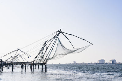 Sailboats in sea against clear sky