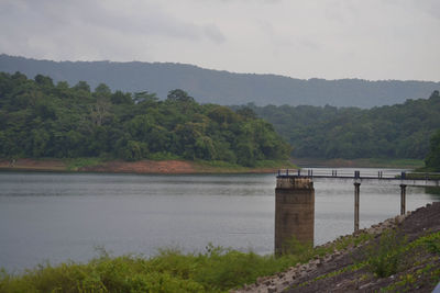 Scenic view of river by trees against sky