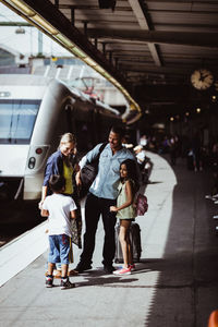 Family greeting man at railroad station