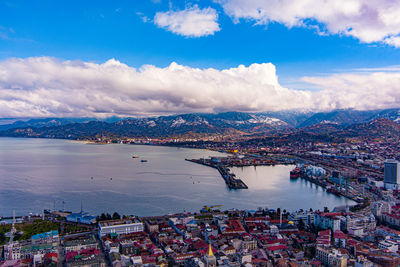 High angle view of city by sea against sky