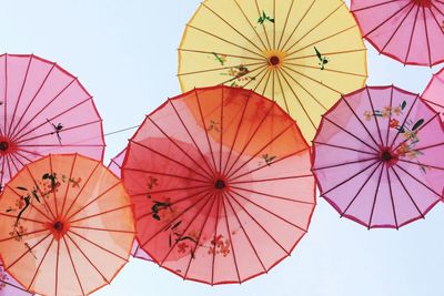 Low angle view of multi colored paper umbrella against clear sky