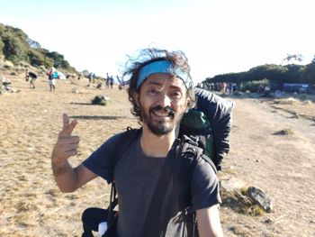 Portrait of young man standing against mountain