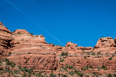 Low angle view of rock formation against clear blue sky