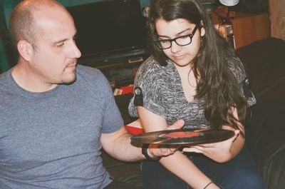 Father with daughter holding record at home