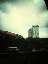 Low angle view of buildings against cloudy sky