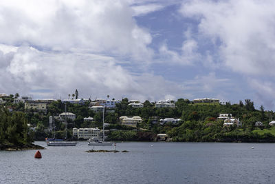 Sailboats in sea against buildings in city