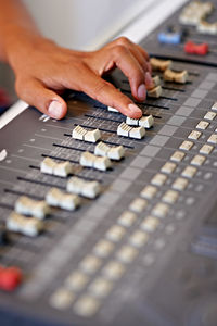 Cropped hand of person using music mixer