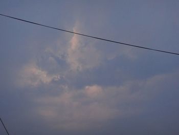 Low angle view of power lines against blue sky