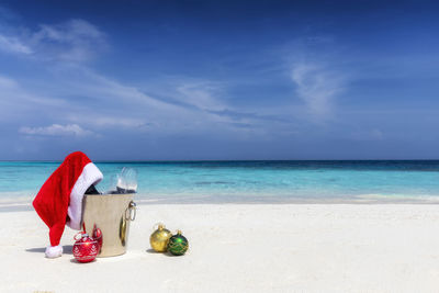 Christmas decoration at beach against sky