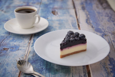 Coffee cup and cake on table