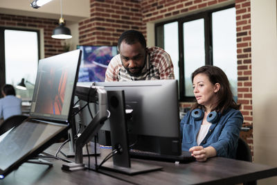 Side view of man using laptop at office