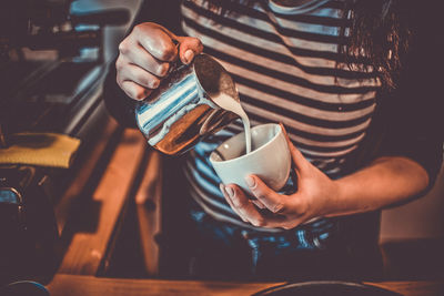 Midsection of man holding coffee cup