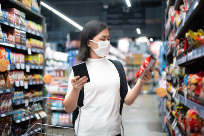 Woman using mobile phone at store