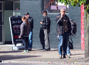 Men standing on sidewalk in city