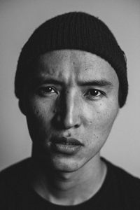 Close-up portrait of young man against gray background