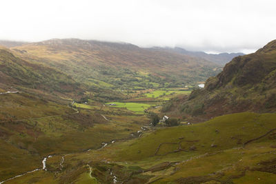 Scenic view of valley and mountains against sky
