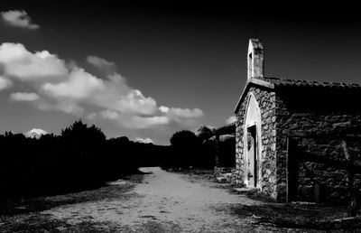 Abandoned building by trees against sky