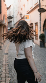 Midsection of woman standing on street in city